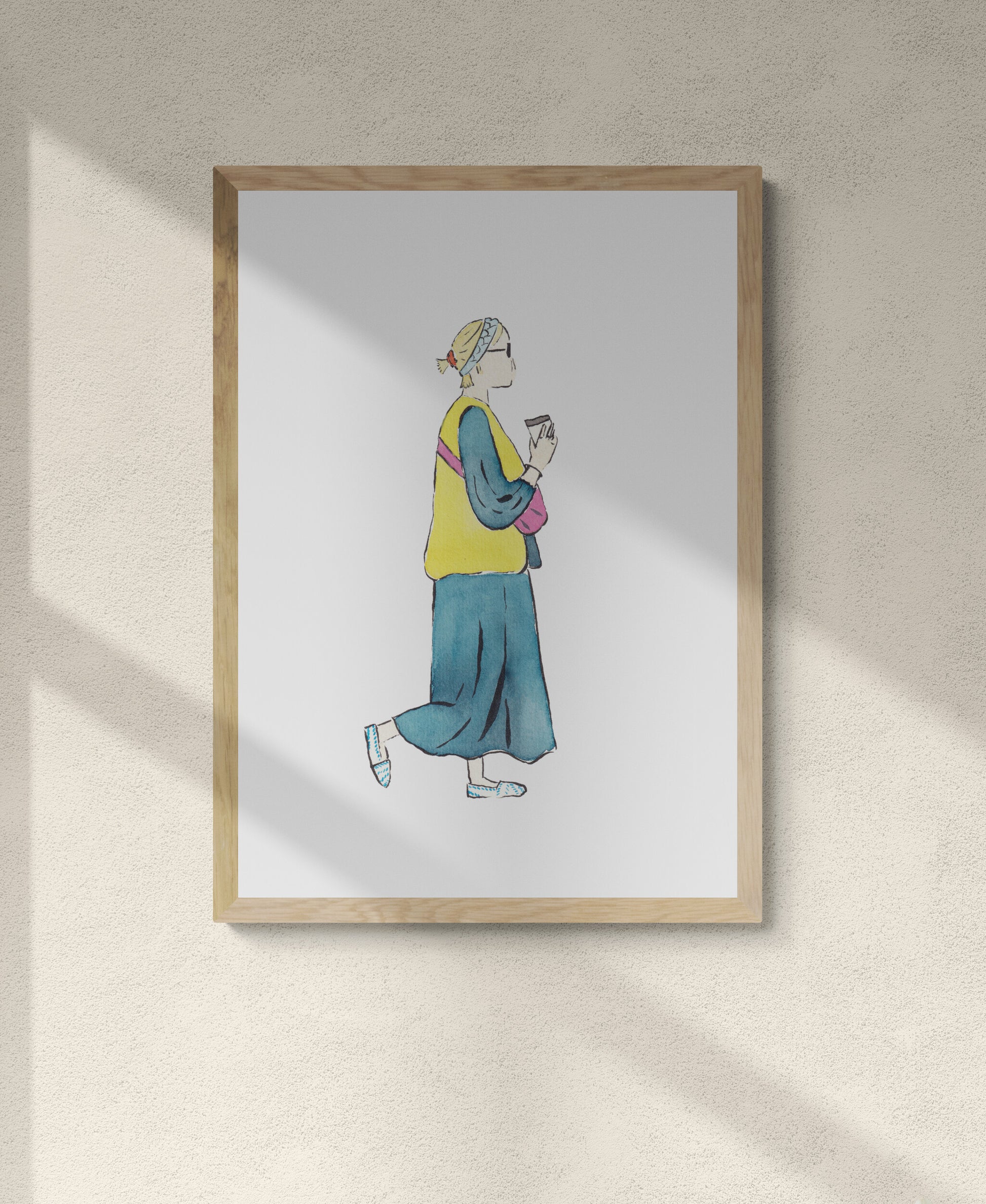 Framed artwork of a girl walking with coffee in hand in a cute spring outfit of long denim dress with yellow vest pink bag and white and blue shoes with blue headband and orange scrunchie