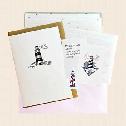 a flat lay of February print club greeting card lighthouse sticker mini print word of the month letter and premium packaging affordable art